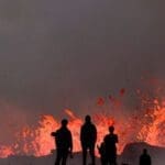 வெடித்துச் சிதறும் எரிமலை: அருகே செல்லும் சுற்றுலாப்பயணிகள்